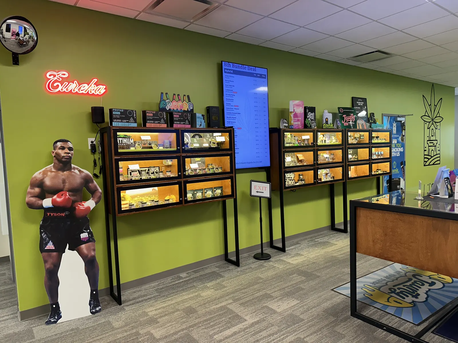 Lit wood display cases along the green wall of the store
